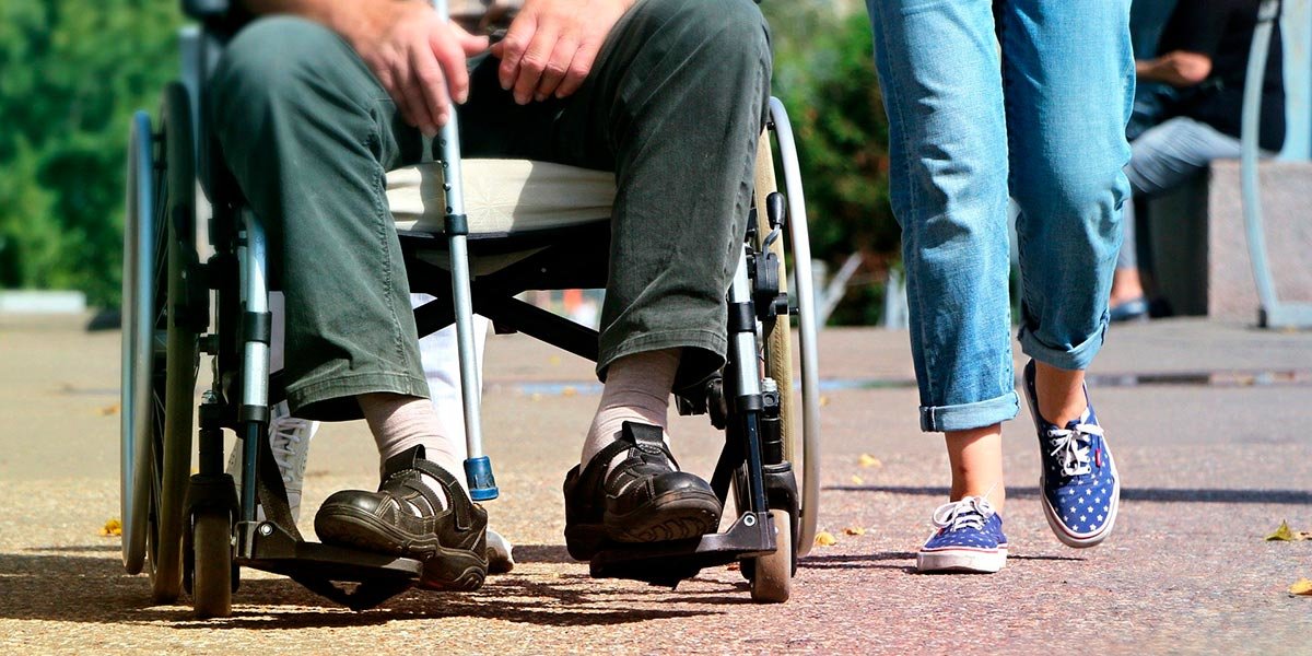 silla de ruedas cuidador anciano paseo dependencia
