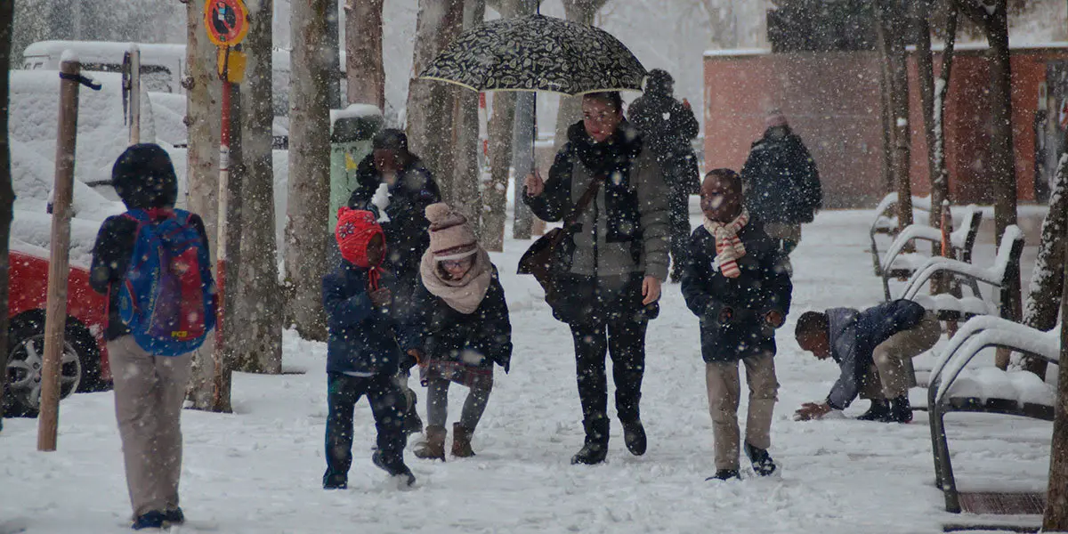 Unos ni&ntilde;os disfrutan de la nieve de camino a clase esta ma&ntilde;ana