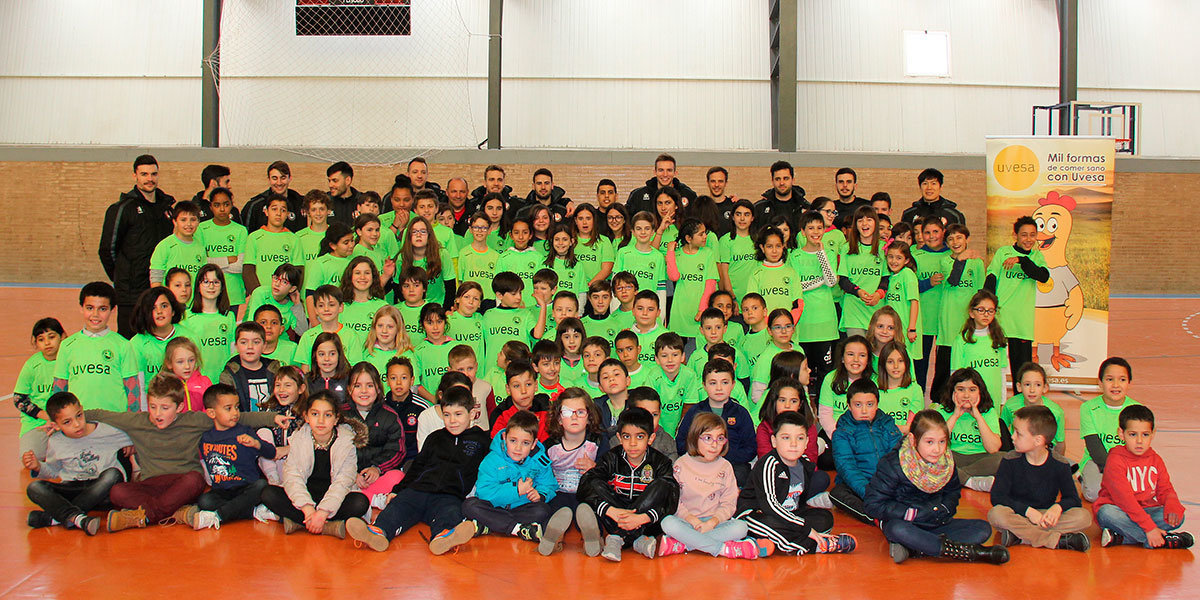 Los jugadores del Ribera Navarra junto con los alumnos del colegio