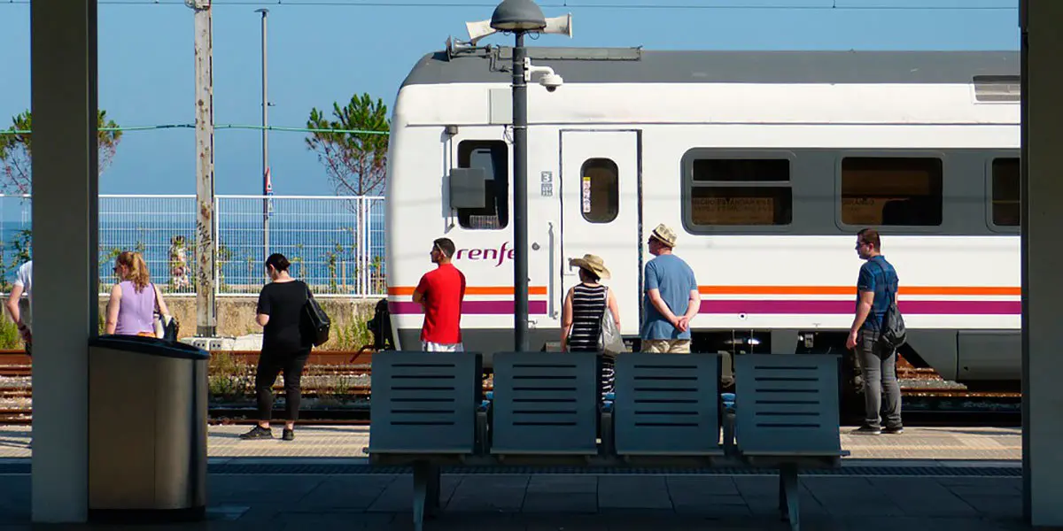 Unos pasajeros esperan al tren