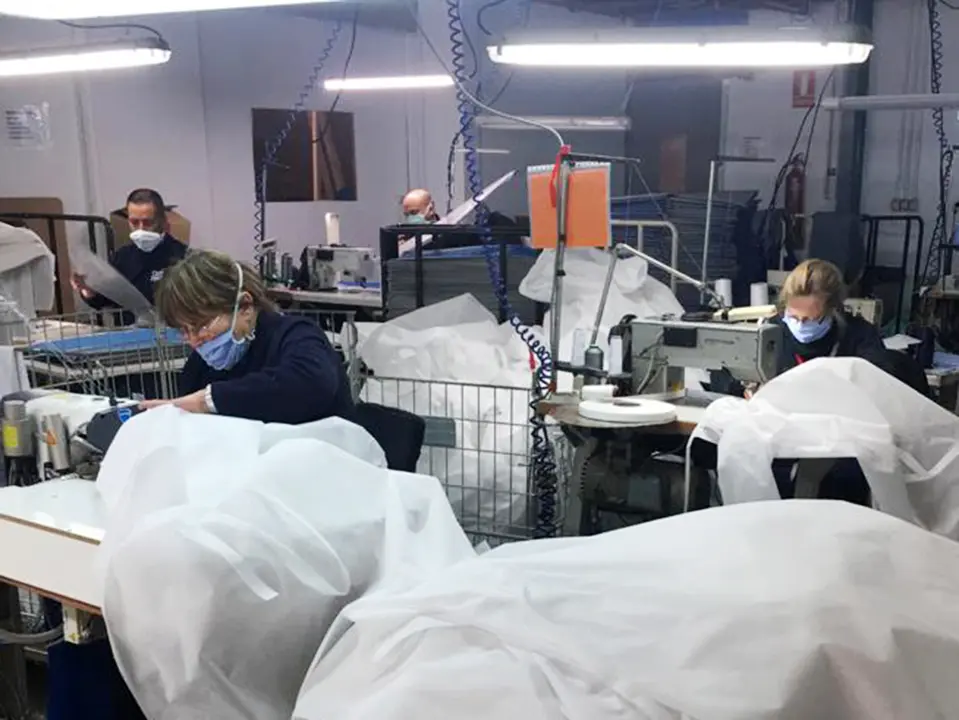 Trabajadores de AMIMET confeccionando batas