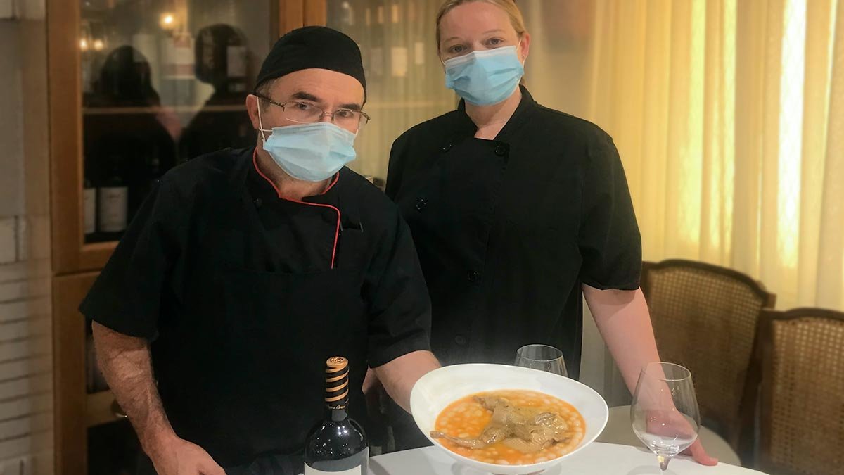 Juanjo y Begoña, cocineros del restaurante La Parrilla, con un plato de pochas con codorniz