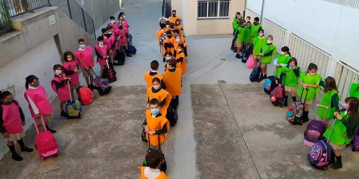 Ni&ntilde;os con los petos de colores a la entrada del Colegio