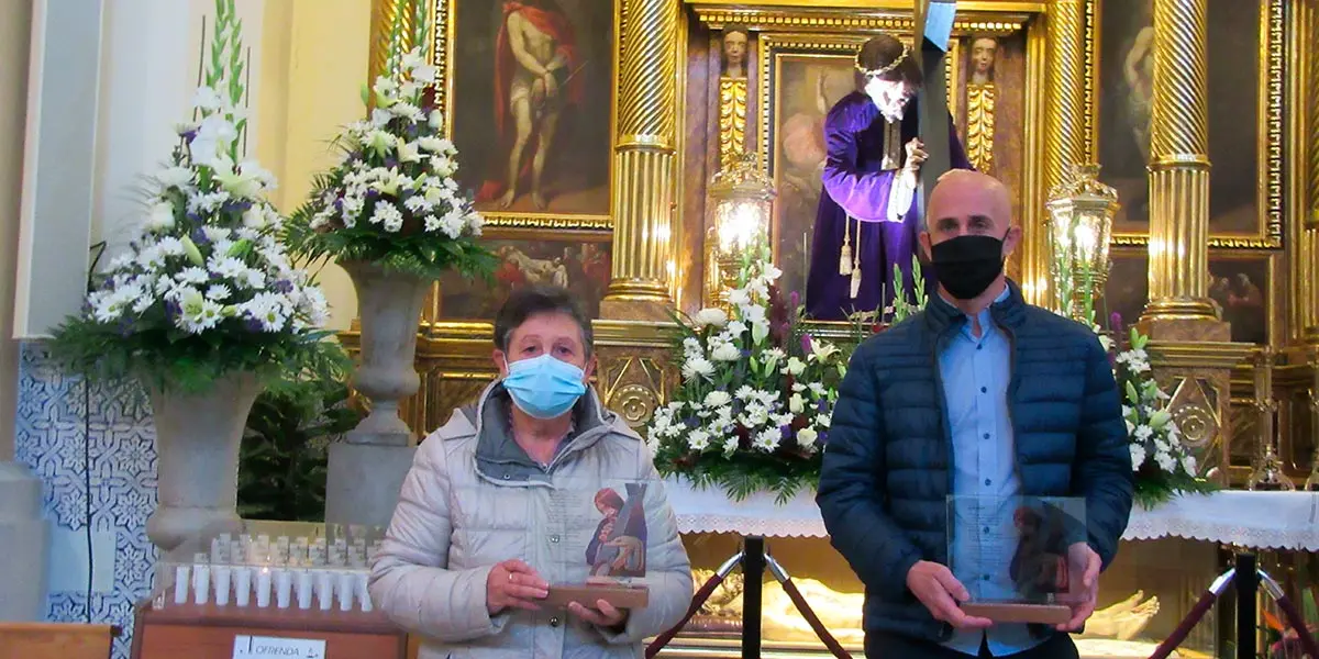 Los familiares de los fallecidos con una placa con la foto del Santo Cristo y un poema escrito por Isidro S&aacute;nchez