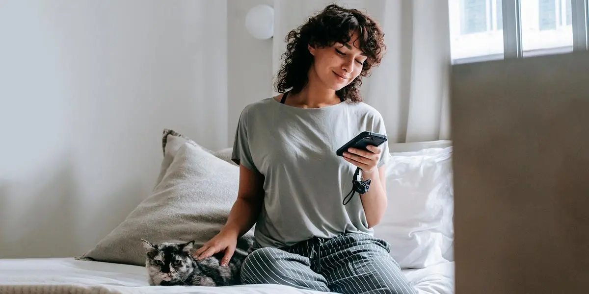 m&oacute;vil tel&eacute;fono hogar gato cama chat mujer chica tecnolog&iacute;a WhatsApp compra online