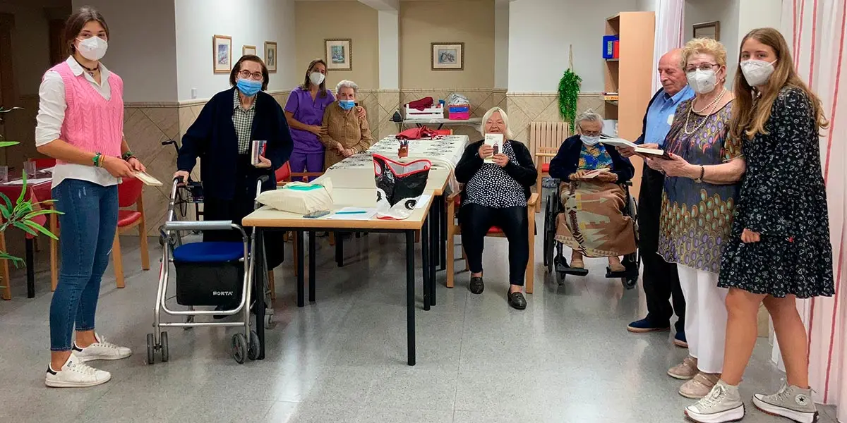Lorena Mart&iacute;nez y Aizea Garc&iacute;a haciendo entrega de un lote de libros para los residentes de Fusti&ntilde;ana