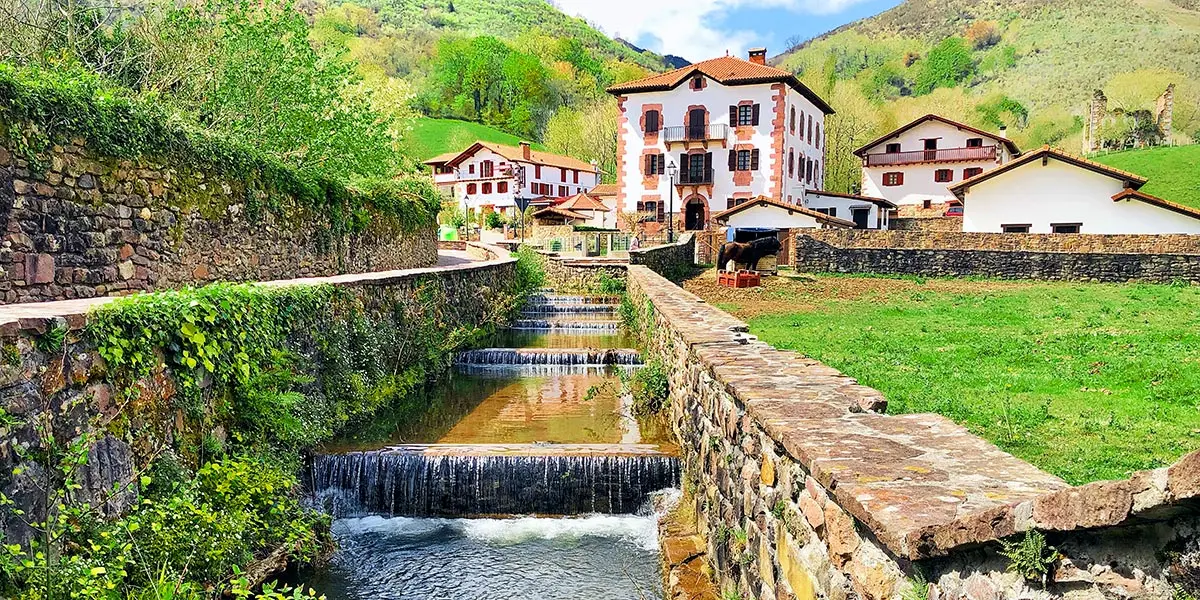 Un canal y, al fondo, el pueblo de Urdax y las monta&ntilde;as. Foto: Iker Beroiz