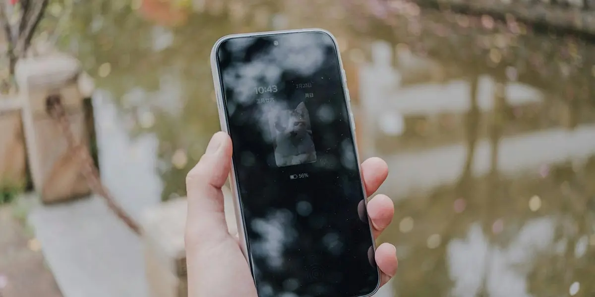 Una mano que sostiene un tel&eacute;fono m&oacute;vil inteligente con reflejos