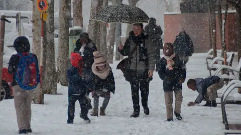 Unos ni&ntilde;os disfrutan de la nieve de camino a clase esta ma&ntilde;ana