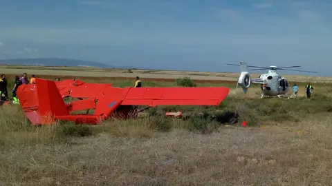 La avioneta accidentada junto al helic&oacute;ptero medicalizado