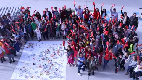 Los participantes en la iniciativa rodean los envoltorios de los almuerzos y saludan con los nuevos porta bocadillos