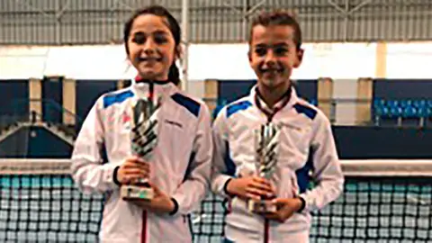 María con su rival en la Final Sub-10, Idoia Razquin, y con sus Trofeos en la mano