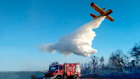 Un avi&oacute;n Foca realiza una descarga de agua sobre los &aacute;rboles afectados por el incendio