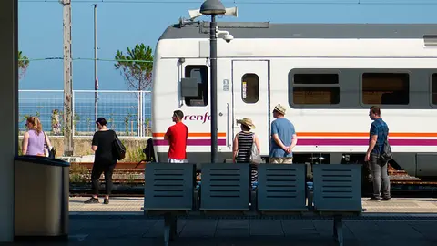 Unos pasajeros esperan al tren