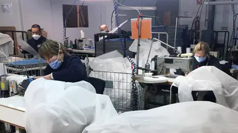 Trabajadores de AMIMET confeccionando batas