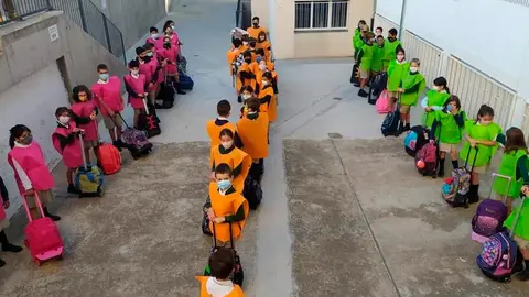 Ni&ntilde;os con los petos de colores a la entrada del Colegio