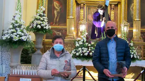 Los familiares de los fallecidos con una placa con la foto del Santo Cristo y un poema escrito por Isidro S&aacute;nchez