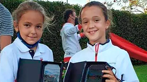 Daniela, a la derecha de la foto, con su trofeo regalo de campeona