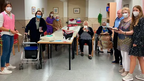 Lorena Mart&iacute;nez y Aizea Garc&iacute;a haciendo entrega de un lote de libros para los residentes de Fusti&ntilde;ana