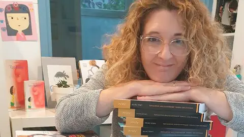 Leticia Garc&eacute;s Larrea apoyada sobre una pila de ejemplares de su segundo libro 'Infancia bien tratada, adolescencia bien encaminada'