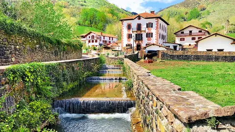 Un canal y, al fondo, el pueblo de Urdax y las monta&ntilde;as. Foto: Iker Beroiz
