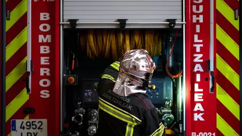 Un bombero prepara el cami&oacute;n de extinci&oacute;n de incendios.