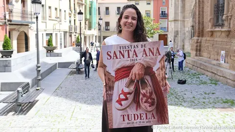 La tudelana Ana Mart&iacute;nez Salvador posa junto al cartel ganador de las Fiestas de Santa Ana 2026, titulado &lsquo;7 d&iacute;as para dejar huella&rsquo;