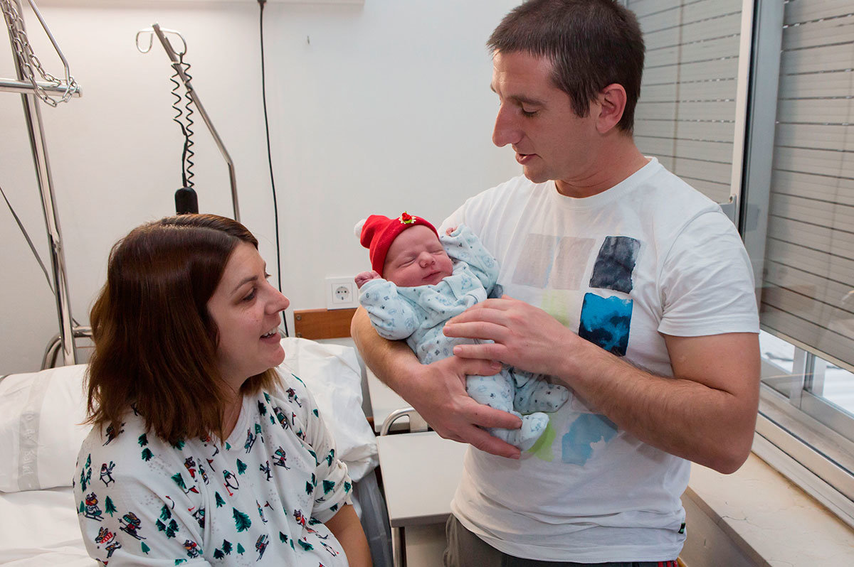 Los padres del primer nacido en 2020 en Pamplona, con el niño.