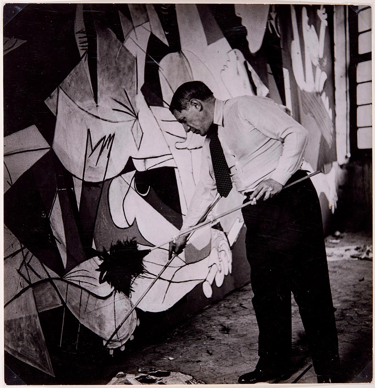 Pablo Picasso de pie trabajando en Guernica en su taller de los Grands-Augustins, mayo-junio 1937