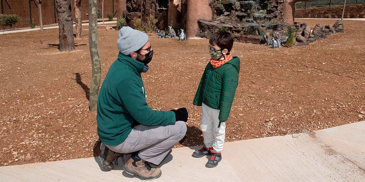 El niño David González Antona, de 5 años, atiende las explicaciones del cuidador Christian Herrero Arenales en el nuevo recinto de lémures de cola anillada