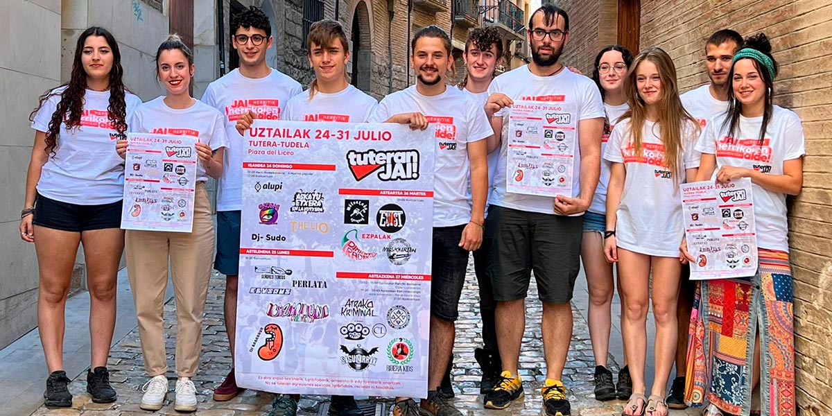 Grupo de integrantes de Tuteran Jai con su cartel de actos para fiestas