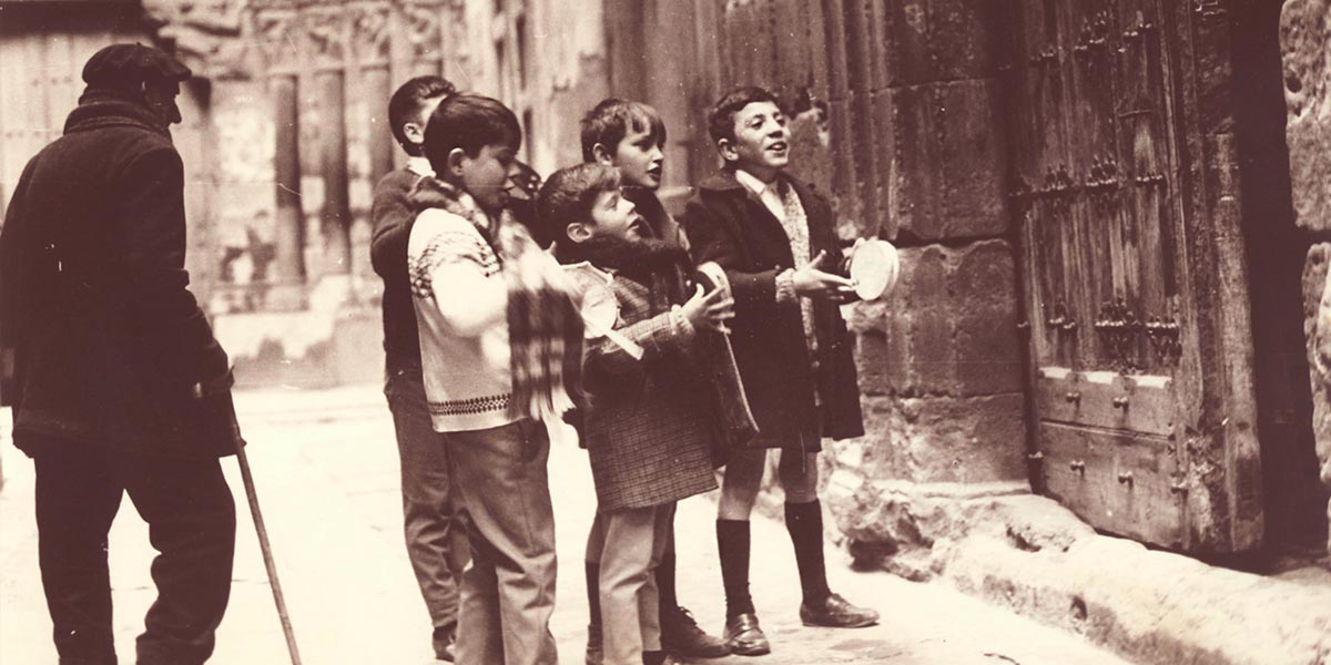 Unos chavales rondando y pidiendo aguinaldos en una casa delante de la Puerta del Juicio
Fotografía: Luis M.ª Marín Royo