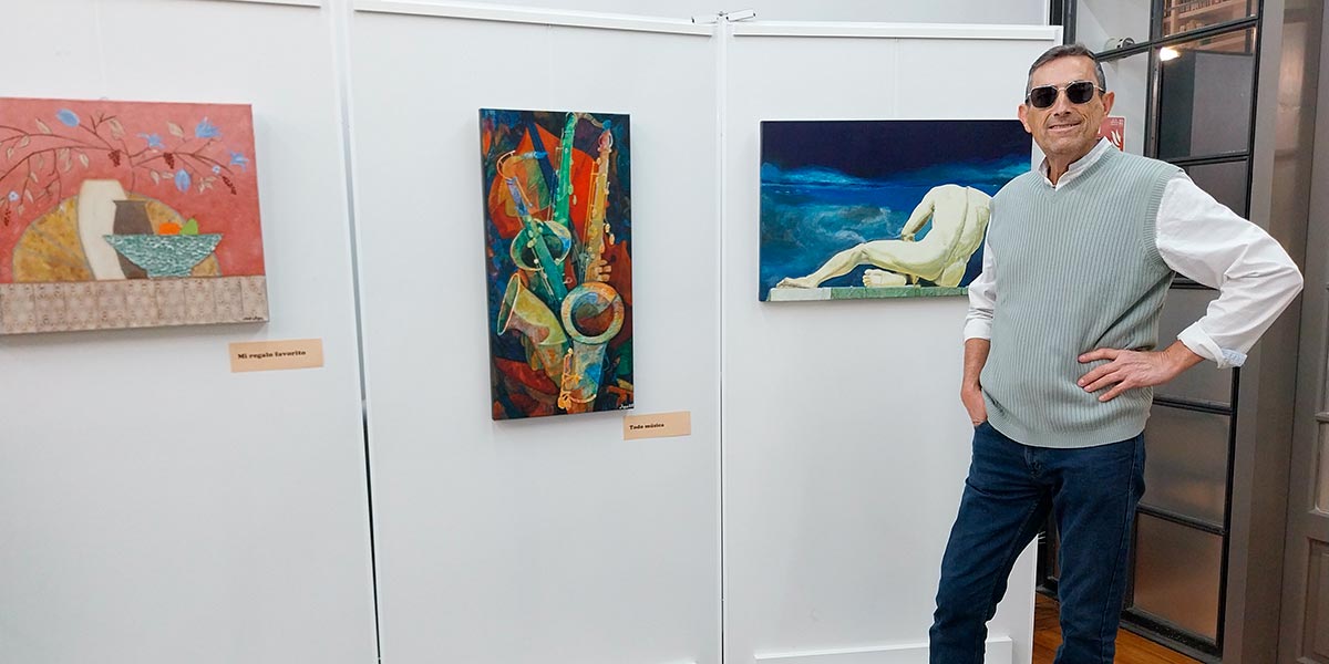 Agustín Zamora junto a algunas de sus pinturas
