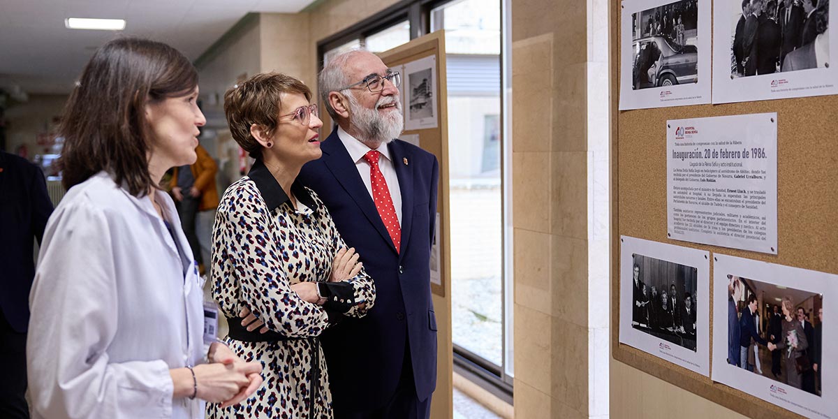 La Presidenta María Chivite junto con el consejero Fernando Domínguez y Ana Campillo, miran fotos de la inauguración del Hospital Reina Sofía hace 40 años