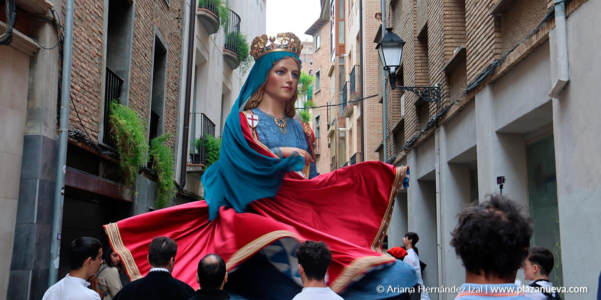 Los gigantes Perrinche, acompañados por el público, se dirigen hacia la Catedral de Tudela en la marcha previa a la Misa Navarra