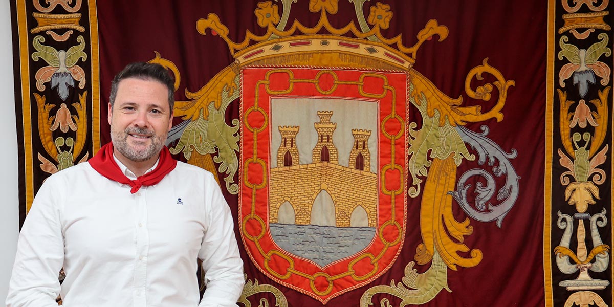 Alejandro Toquero, junto al escudo de Tudela, ciudad de la que es alcalde desde 2019