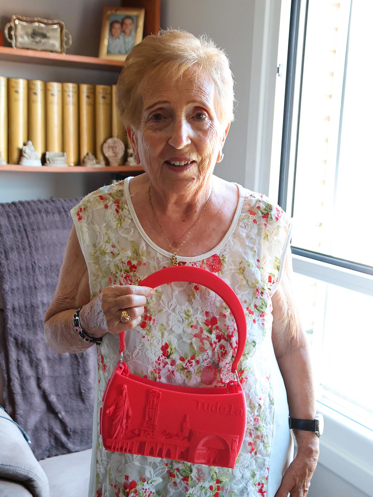 Mari Carmen Pérez Salas muestra un bolso confeccionado por su nieta con motivos de las fiestas de Tudela. Al cuello, luce la medalla de Santa Ana que siempre la acompaña